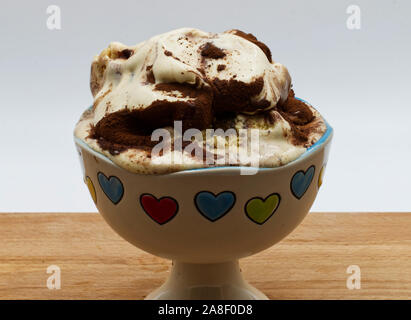 Tasse de crème glacée Tiramisu sur table en bois, fond blanc. Banque D'Images