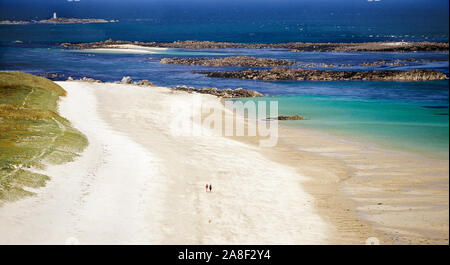 Channel Islands. Bailliage de Guernesey. L'île de Herm. Plage de sable blanc avec lointain, vue arrière de couple en train de marcher. Banque D'Images