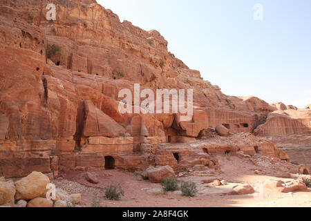 Façades de la rue, qui est, avec les portes des grottes creusées dans la pierre rouge, Petra, Jordanie. Banque D'Images