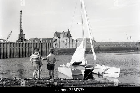 Enfants jouant par l'estuaire près des quais, Cockermouth, Cumbria, UK 1958 Banque D'Images