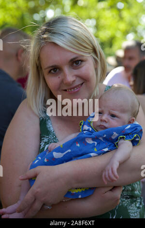 Mère avec son nouveau-né fille lors d'une fête d'été. Banque D'Images