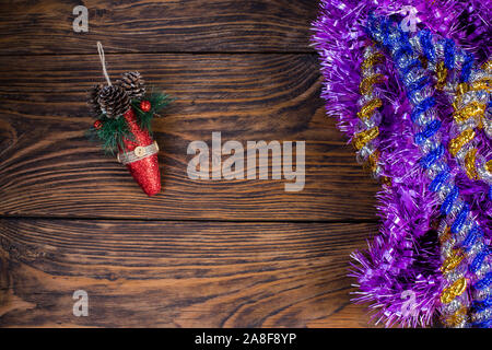 Un arbre de Noël et des jouets en bois brun violet tinsel sur arrière-plan. Banque D'Images