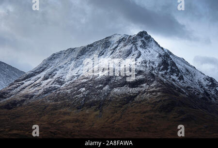 Crête de montagne enneigées dans les highlands écossais pendant le changement de saison de l'automne à l'hiver.Première neige et couleurs d'automne dans la vallée.paysage majestueux. Banque D'Images