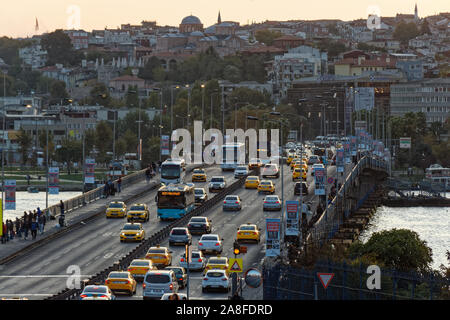 Conduite de véhicules par Unkapani Bridge au coucher du soleil l'heure. Vues avant et arrière de taxis, voitures, autobus et autocars. Banque D'Images