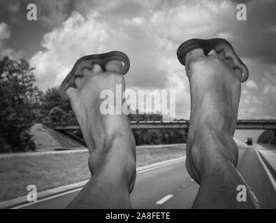 POV, yoga toe brancards avec des pieds levé sur planche de bord sont grands pour les passagers dans un voyage RV, une descente par la route de la Floride en noir et blanc Banque D'Images