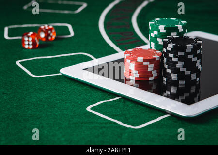 Jeu de poker en ligne et gratuit. Des jetons de poker et un tableau numérique sur un feutre vert Banque D'Images