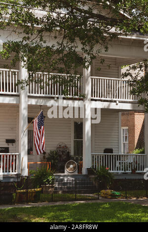 Close up of style Antebellum maison avec véranda et balcon blanc, avec le drapeau américain à Hattiesburg, MS, ETATS UNIS Banque D'Images