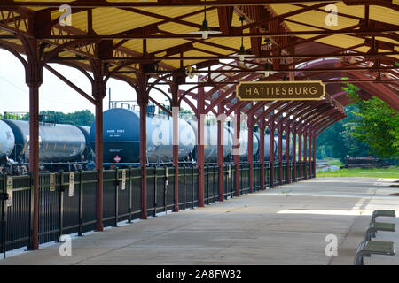 Passage couvert pour l'aire d'attente pour l'embarquement des passagers à l'Hattiesburg, MS, train depot, avec signe de la plaque signalétique et les pétroliers à proximité, Hattiesburg, Banque D'Images