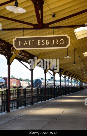 Passage couvert pour l'aire d'attente pour l'embarquement des passagers à l'Hattiesburg, MS, train depot, avec signe de la plaque signalétique et les pétroliers à proximité, Hattiesburg, Banque D'Images