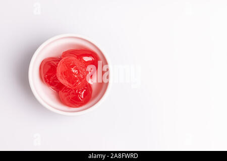 Cerise au marasquin dans un bol blanc, isolé sur fond blanc, une lumière douce, studio shot Banque D'Images