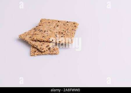 Le régime alimentaire des graines de lin craquelins à grains entiers isolé sur fond blanc, lumière douce, copy space Banque D'Images