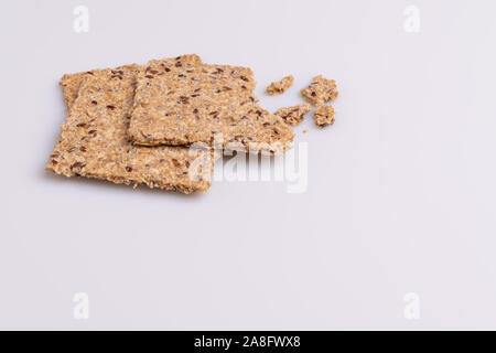 Le régime alimentaire des graines de lin craquelins à grains entiers isolé sur fond blanc, lumière douce, copy space Banque D'Images