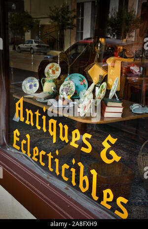 Un charmant vieux collectibles shop/fenêtre avec le nom du magasin peint en jaune, 'Antiquités & Eclecticibles', dans le centre-ville de Hattiesburg, MS, ETATS UNIS Banque D'Images