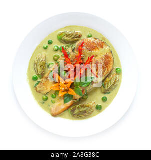 Curry vert avec le saumon dans la sauce au lait de coco cuisine fusion thaï décorer style sculpté légumes piment et basilic thaï vue supérieure Banque D'Images