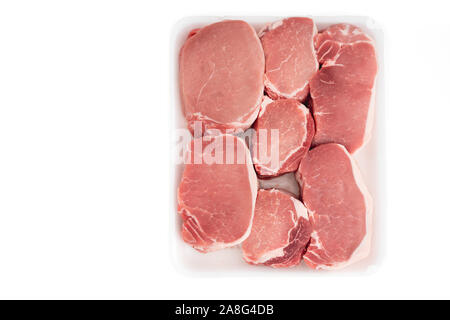 Côtelettes de longe de porc désossé de matières premières en plastique blanc contenant, Close up, directement à partir de ci-dessus, isolé sur fond blanc Banque D'Images