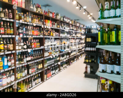 Image floue de vin étagères afficher dans un supermarché. Defocused Rangées de bouteilles d'alcool de vin sur l'étagère du magasin. Boissons alcoolisées abstract background Banque D'Images