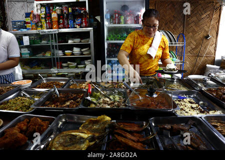 TAYTAY, Rizal, PHILIPPINES - 7 novembre, 2019 : femme sert un assortiment de plats faits maison au restaurant local ou un restaurant appelé "Karinderia" qui sert home Banque D'Images