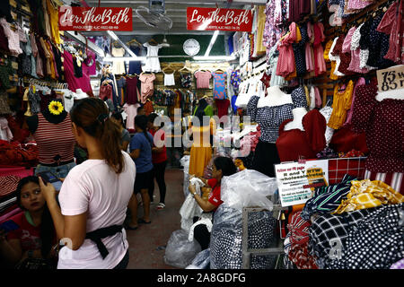 TAYTAY, Rizal, PHILIPPINES - Novembre 7, 2019 : un assortiment de vêtements et chaussures à prix abordable sur l'affichage à un bazar arrête sur une place populaire bazar ou loca Banque D'Images