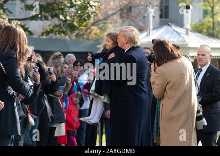 Le Président des Etats-Unis, Donald J. Trump embrasse une jeune fille tout en prenant une photo avec elle sur la pelouse Sud de la Maison Blanche à Washington, DC, États-Unis, il part pour un voyage de jour à Marietta, Géorgie le vendredi, Novembre 8, 2019. Credit : Stefani Reynolds/CNP /MediaPunch Banque D'Images