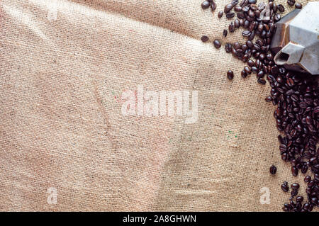 Les grains de café et espresso pot isolé sur fond de toile. Arrière-plan ou de la texture pour un café dans un style rustique. Banque D'Images