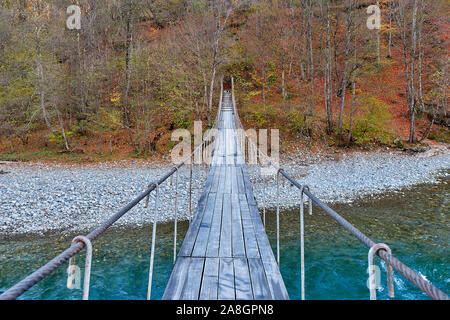 Un pont suspendu au-dessus de la rivière de montagne Banque D'Images
