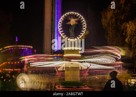 Un carrousel coloré floue en mouvement au parc d'attractions, l'éclairage de nuit. Longue exposition. Banque D'Images