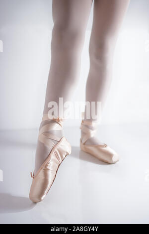 Détail des jambes et des pieds avec des chaussons de satin rose par un danseur classique posing Banque D'Images