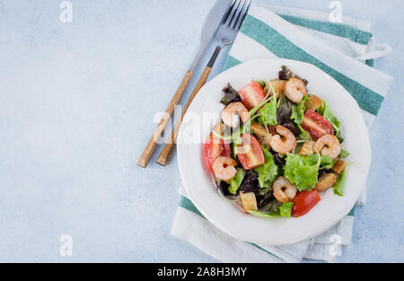 Salade fraîche sur plaque blanche avec de la laitue, de cerise, de parmesan et de crevettes sur table en pierre historique. Healhty Snack Food Concept. Vue supérieure de la Co Banque D'Images