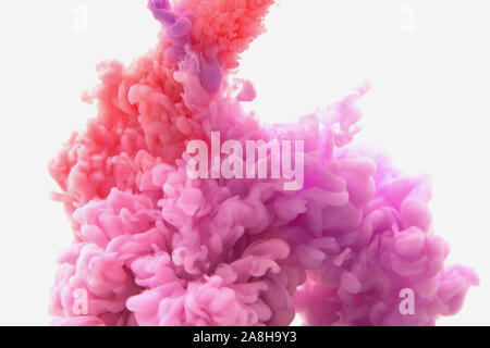 Mélange de rouge et violet abstrait de l'encre dans l'eau sur un fond blanc. Il ressemble à de la fumée ou de nuages. Ou zéro gravité. Banque D'Images