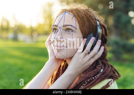 La vérification biométrique d'une jeune femme moderne. Le concept d'une nouvelle technologie de reconnaissance de visage sur grille polygonale est construit dans les points. Banque D'Images