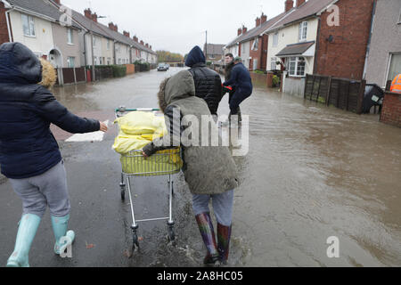 Faites glisser les résidents de sable pour leurs propriétés après les inondations dans la région de Doncaster Bentley après un mois de pluie est tombé en un jour caausing la rivière Don à enfreindre ses banques. Banque D'Images