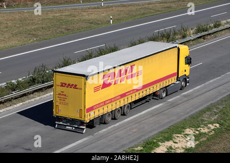 Camion avec remorque DHL curtainside sur autoroute. Banque D'Images