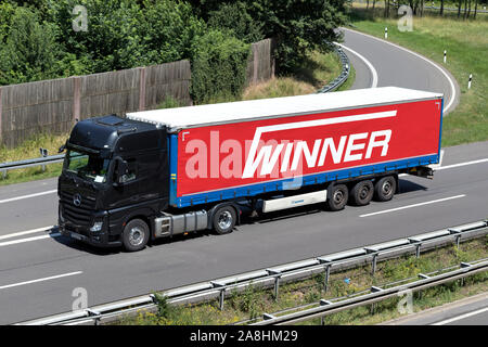 Mercedes-Benz Actros camion avec remorque curtainside gagnant sur autoroute. Banque D'Images