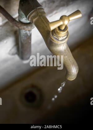 Concept de pénurie d'eau. Ancien robinet d'égoutture qui fuit. Banque D'Images
