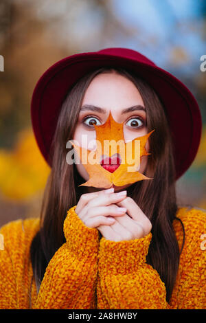 Funny Girl with red lips dans un chapeau le long d'une journée d'automne dans le parc Banque D'Images