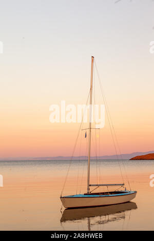 Bateau à voile solitaire au coucher du soleil dans l'île de Lesvos Banque D'Images