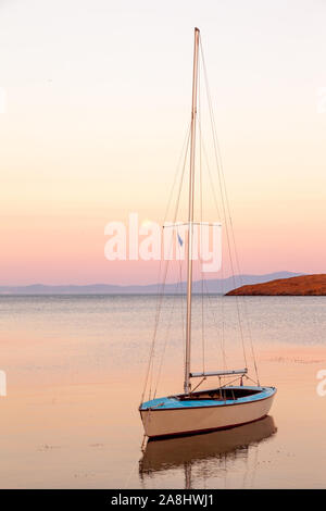 Bateau à voile solitaire au coucher du soleil dans l'île de Lesvos Banque D'Images