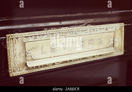 Fente de boîte aux lettres en laiton ancienne porte peinte, close-up, tonique libre Banque D'Images