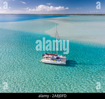 Catamaran à voile avec archipel des Tuamotu en Polynésie française - vue aérienne de la lagune par drone Banque D'Images