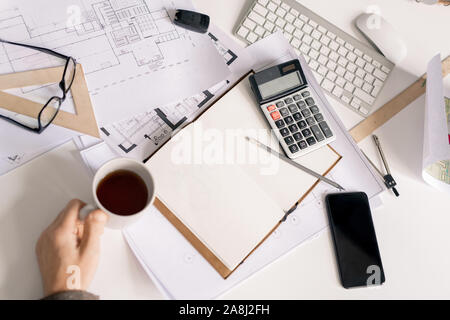 Sommaire des main de l'ingénieur avec tasse de thé noir ou de café par 24 pendant le travail Banque D'Images