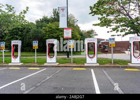 Stations de recharge de Tesla à l'autoroute au Royaume-Uni, de charge électrique, véhicule électrique les points de charge, dans les stations-service, les voitures écologiques Banque D'Images