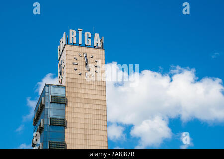 La gare centrale de Riga tour avec nom de la ville et de l'horloge, ciel bleu en arrière-plan Banque D'Images