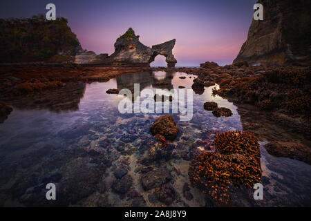 Atuh beach après le coucher du soleil. Barrière de corail à marée basse. Belle arch et Pinnacle. Nusa Penida, Indonésie. L'Heure Bleue. Banque D'Images