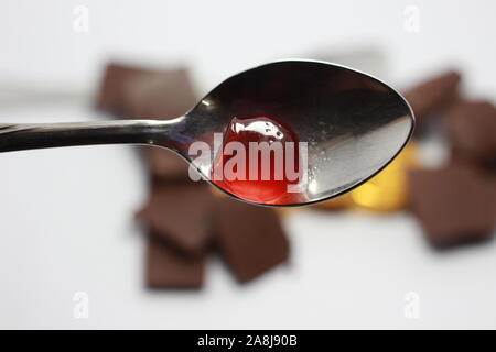 Kids propose de jelly chocolat sur une cuillère Banque D'Images