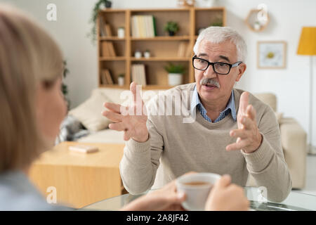 L'homme à la retraite expliquant quelque chose à sa jeune fille au cours de la discussion Banque D'Images