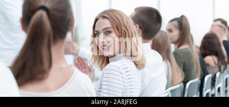 Close up. Jeune femme assise dans une rangée avec ses associés. Banque D'Images