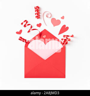Enveloppe rouge avec Valentine hearts et ruban éclater sur un fond blanc. Banque D'Images