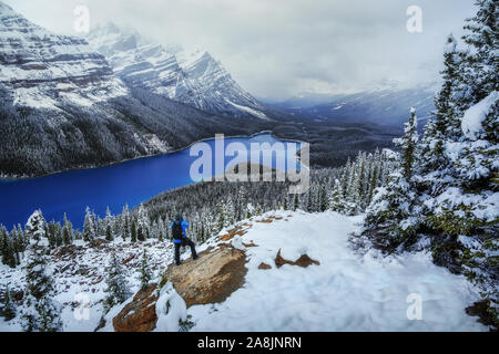 Photographe à Peyto Lake, Canadian Rockies, montagnes Rocheuses, au Canada. Neige et ciel nuageux. Les eaux bleu. Aventurier. Banque D'Images