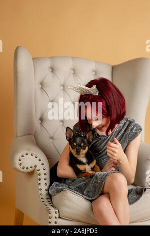 Beauty woman en studio. chihuahua. Nouvelle année session de photo d'une petite fille et un chien. Les cheveux rouges à l'adolescent. Black mini chihuahua. Ch Banque D'Images