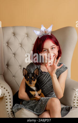 Beauty woman en studio. chihuahua. Nouvelle année session de photo d'une petite fille et un chien. Les cheveux rouges à l'adolescent. Black mini chihuahua. Ch Banque D'Images